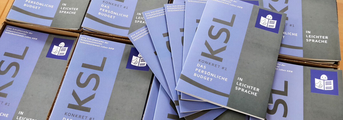 Mehrere Hefte KSL Konkret zum Persönlichen Budget in Leichter Sprache liegen nebeneinander.